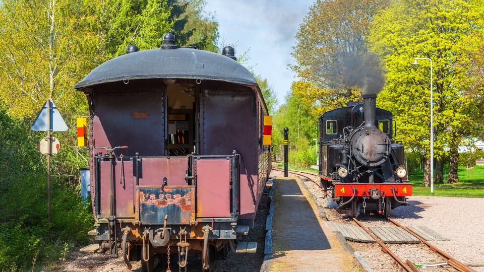 Railway station with a steam locomotive and passenger carriages