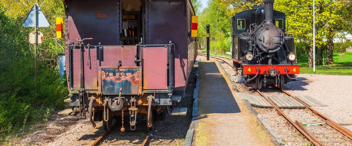 Railway station with a steam locomotive and passenger carriages
