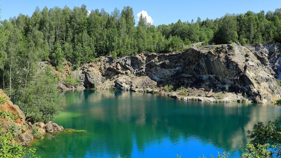 Limestone quarry lake with turquoise water. Summer day in Uskavi, Nora, Bergslagen, Sweden.