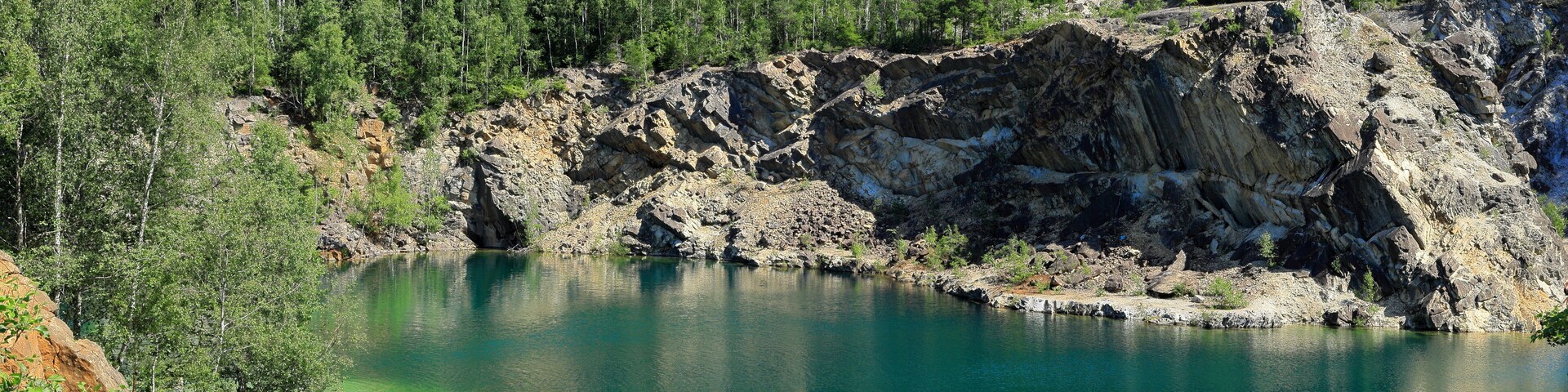 Limestone quarry lake with turquoise water. Summer day in Uskavi, Nora, Bergslagen, Sweden.