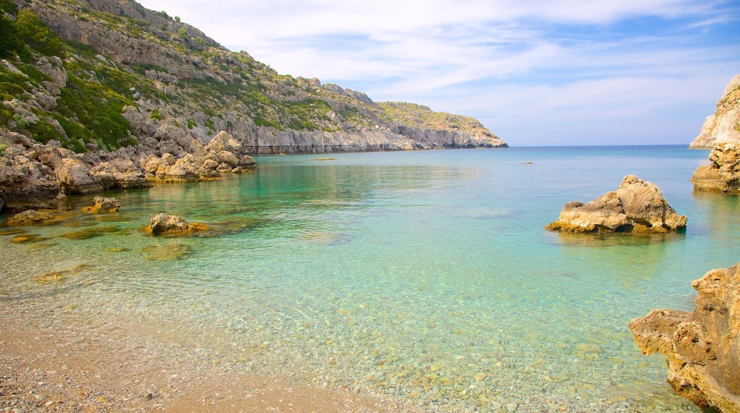 Anthony Quinn Bay showing a bay or harbor, rugged coastline and a pebble beach