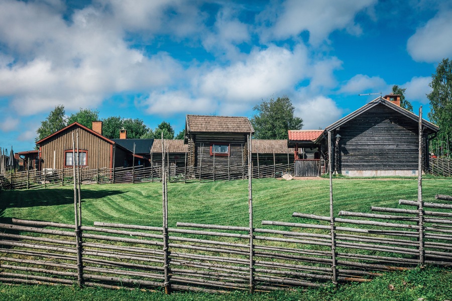 Old Swedish hill fatm with field fence an half timbered buildings.