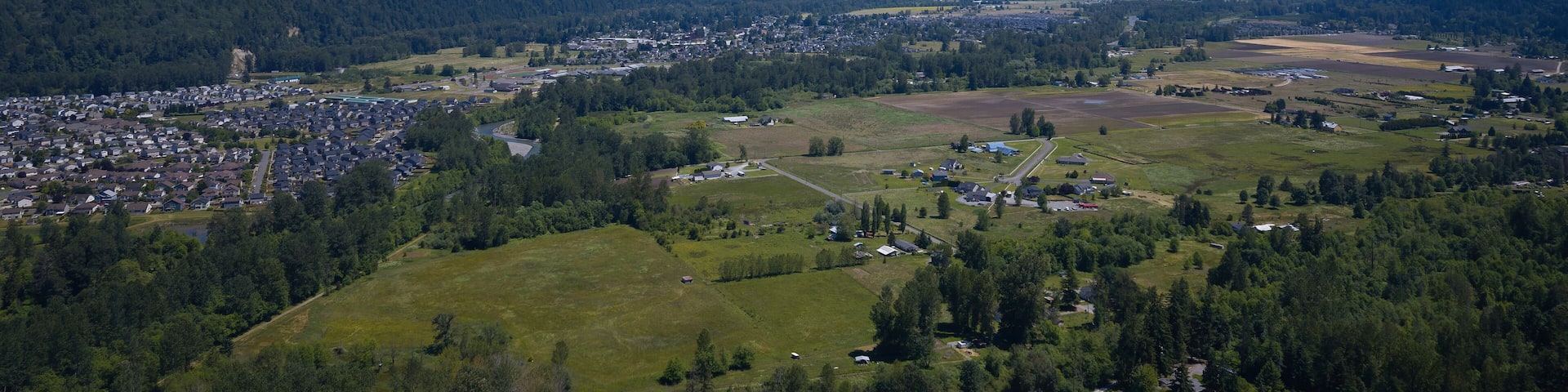 A town nestled in a valley with a snow-capped mountain in the background.