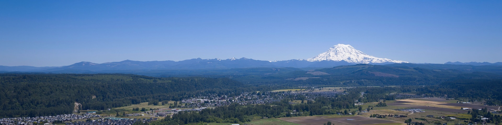 Une ville nichée dans une vallée, avec une montagne enneigée en toile de fond.