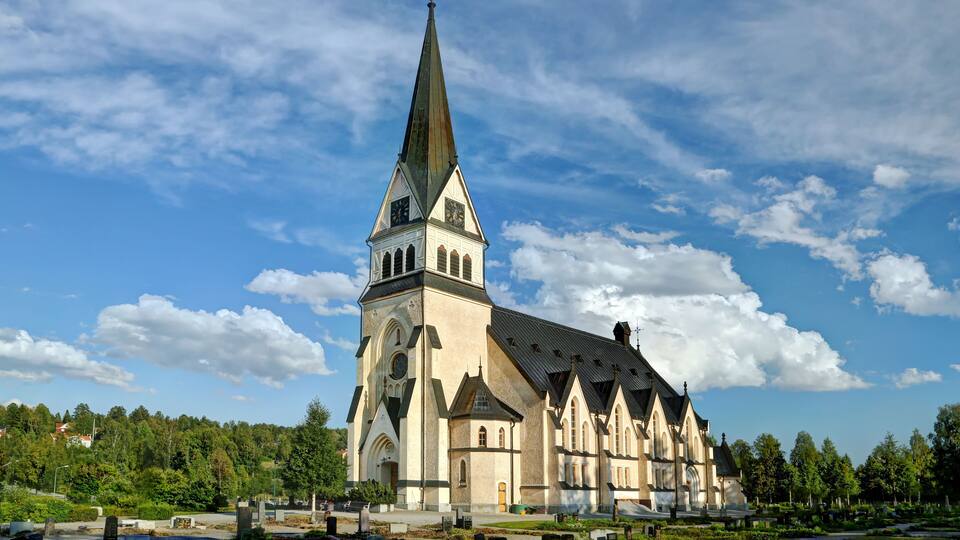 A large church with a tall spire and a clock tower.