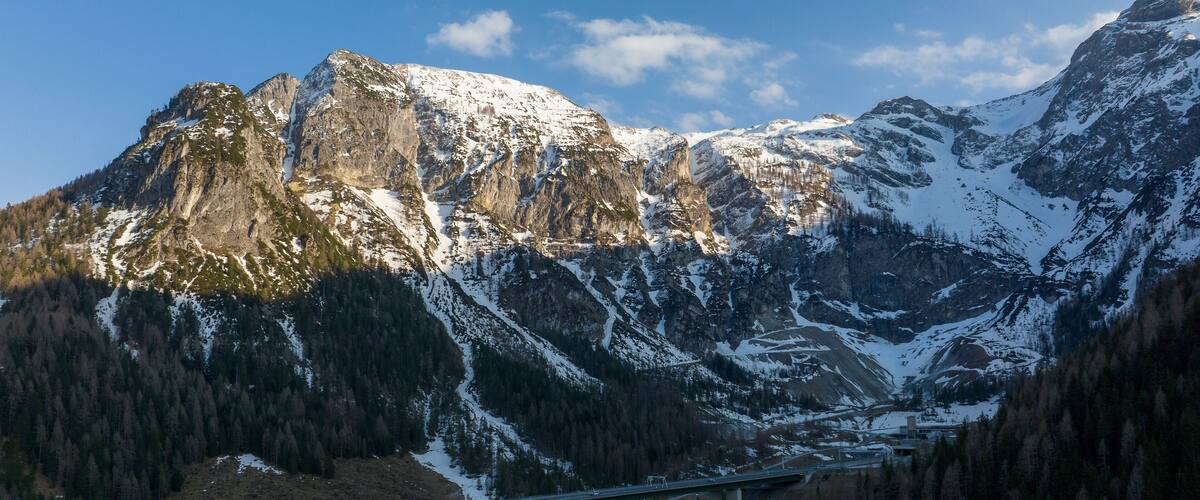 A mountain range with a bridge spanning a valley.