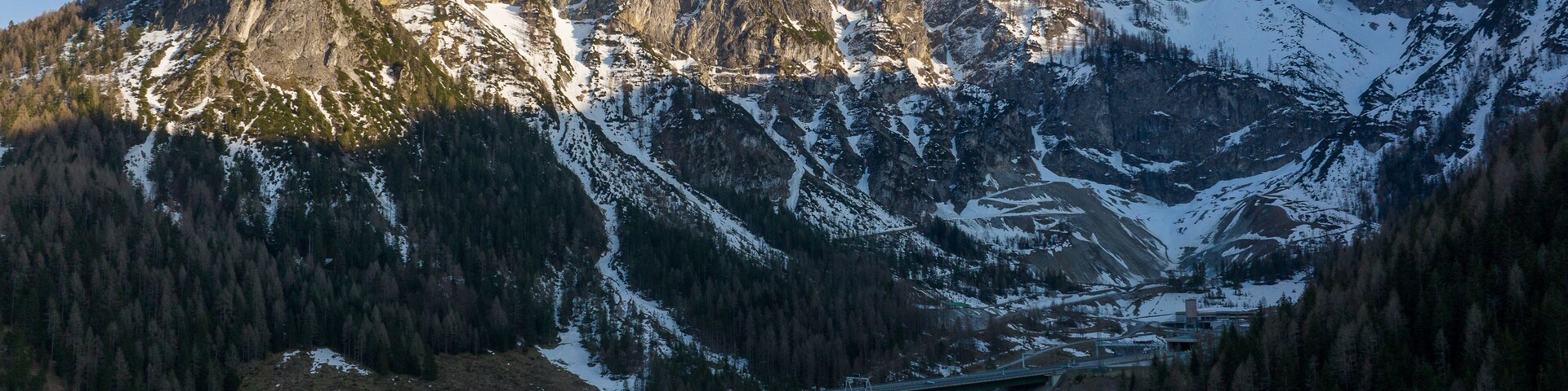 A mountain range with a bridge spanning a valley.
