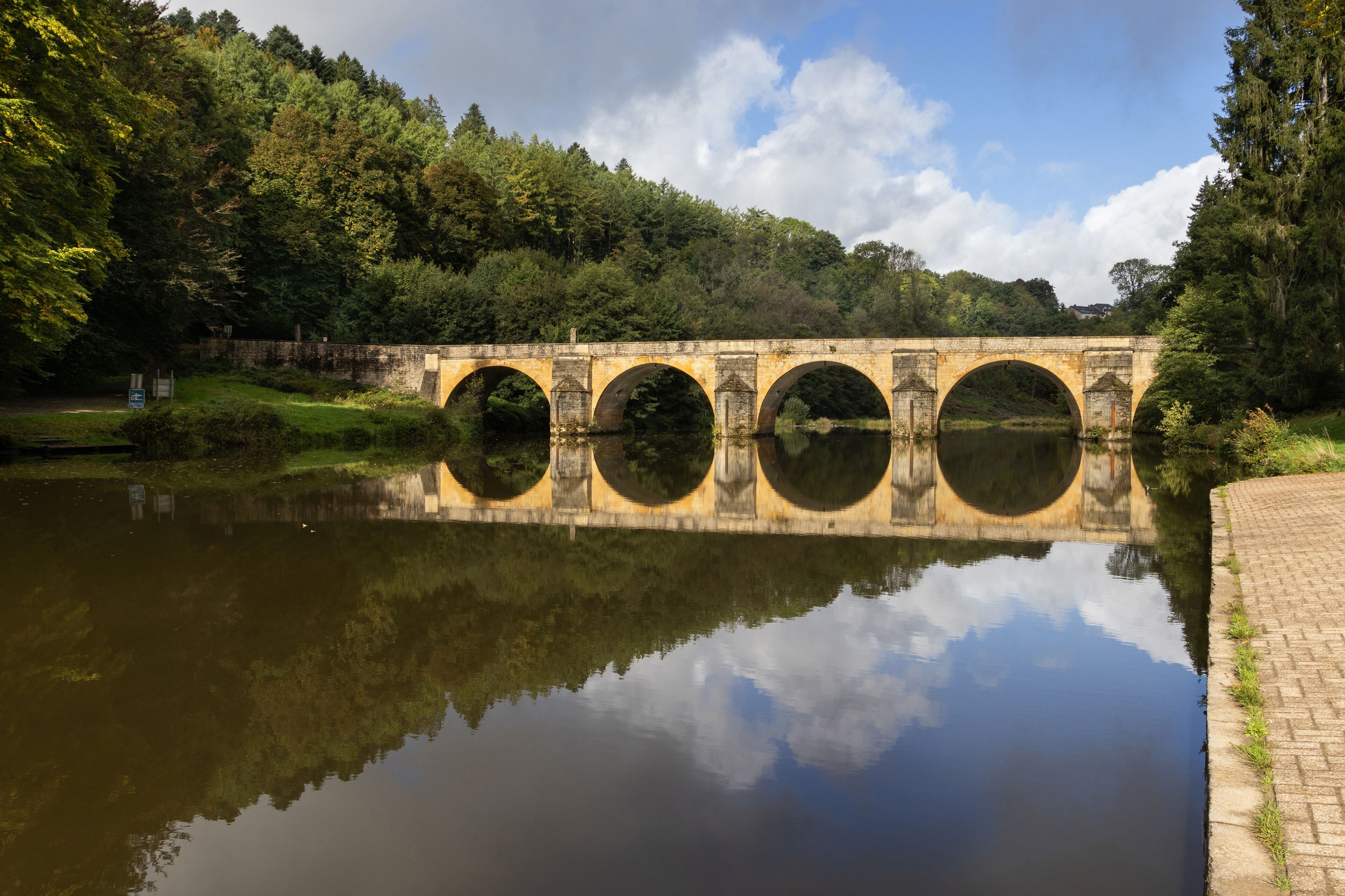 Saint Nicholas Bridge over the Semois River, at Chiny, in the Ardennes Forest in Belgium. Calm early morning scene, with the kayak launch area to the right. Copy space above and below.