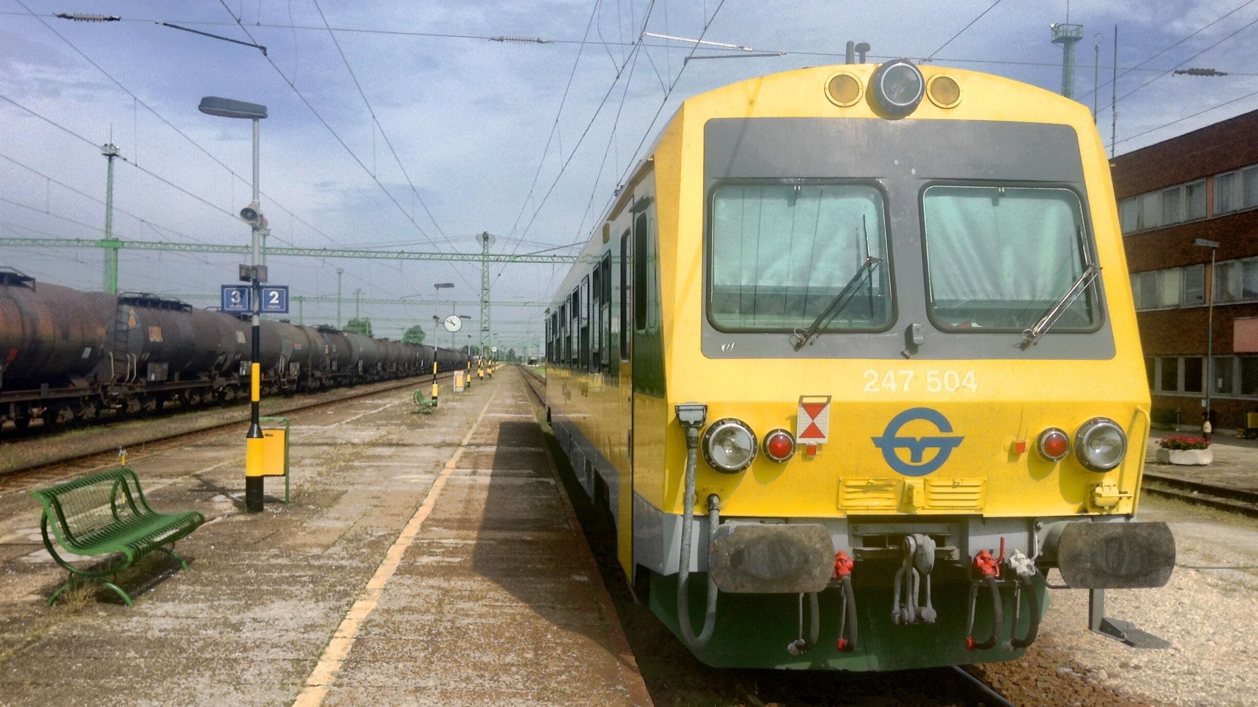 A yellow train with the number 247 504 at a railway station.