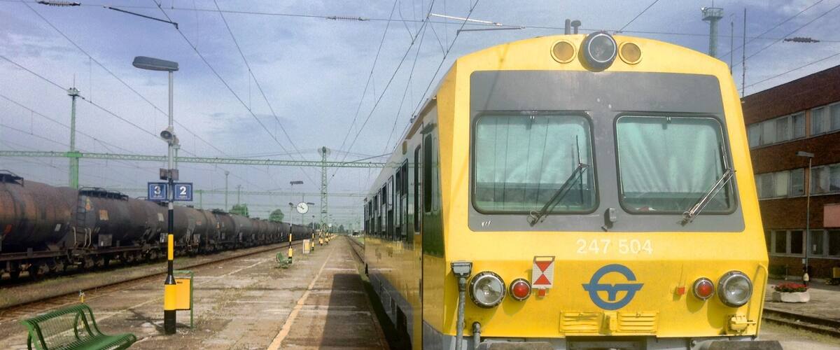 A yellow train with the number 247 504 at a railway station.