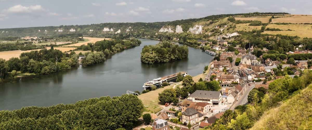 A river winding through a town surrounded by hills and fields.