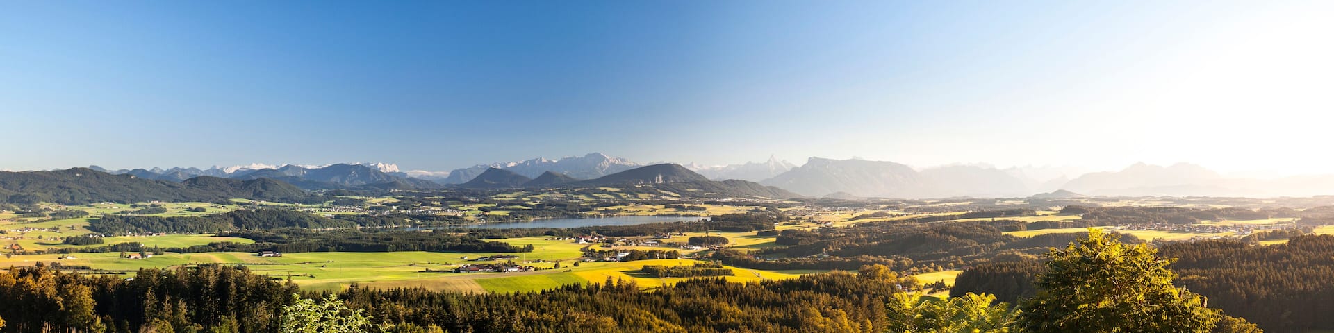 Mountain panorama with lake in Austria. Landscape with mountain view in the sunlight. Bergpanorama mit See. Landschaft mit Blick auf Berge und See im Sonnenlicht. Gebirgskette Salzburgerland.