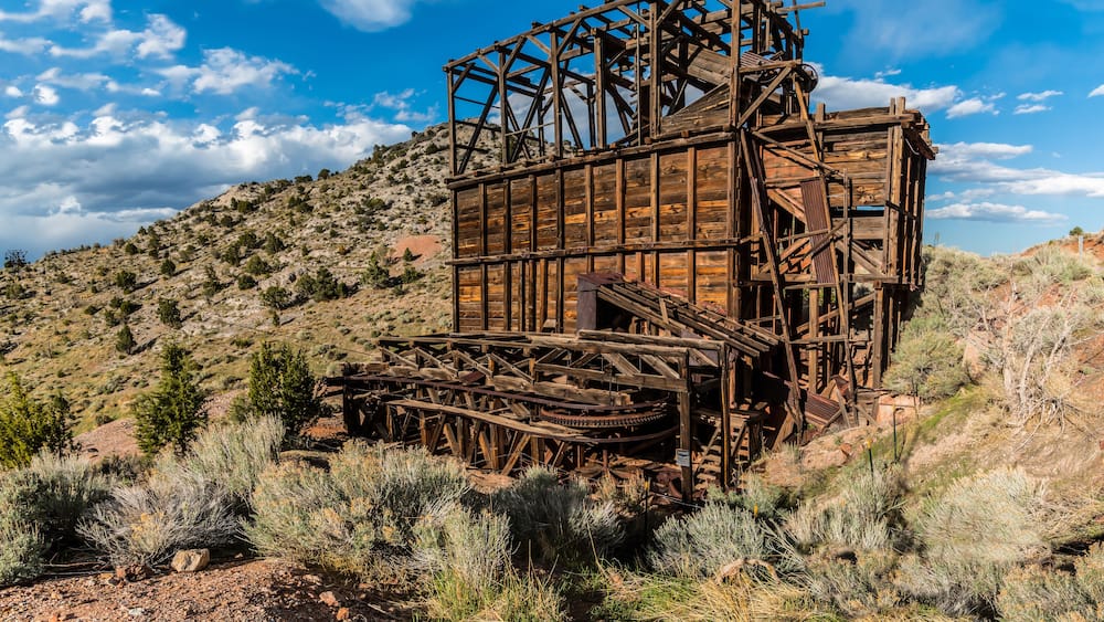 An old wooden water wheel structure in a desert landscape.