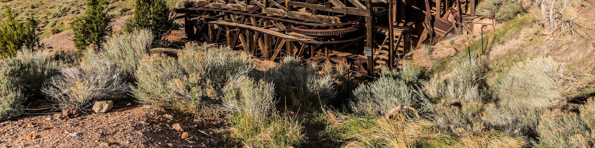 An old wooden water wheel structure in a desert landscape.