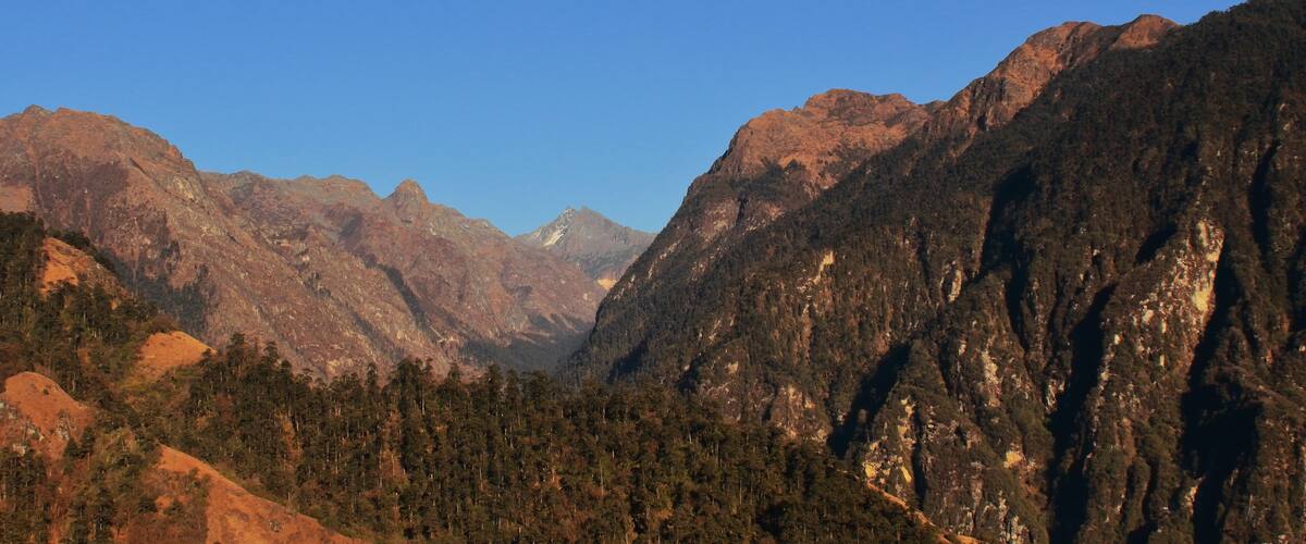 A mountainous landscape with dense forests and rugged terrain.