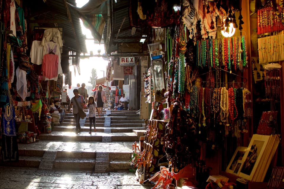 Un marché animé où l’on trouve de nombreux étals vendant des bijoux et des textiles.