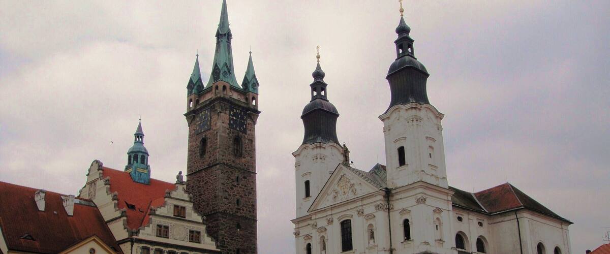 A historic building with two prominent towers and a clock tower.