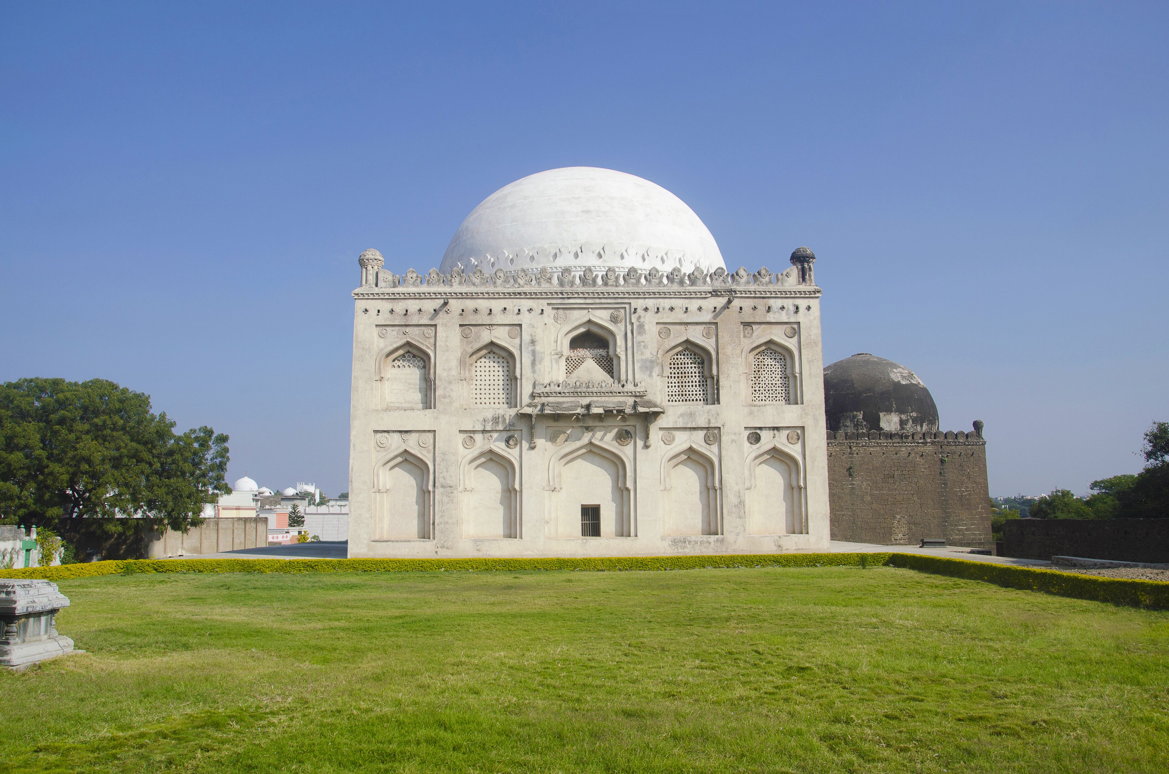 A large white dome structure with intricate architectural details and a smaller dome in the background.