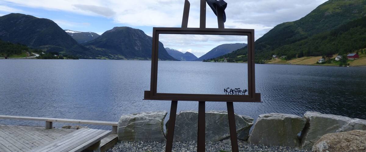 A lake with mountains in the background and a wooden dock.