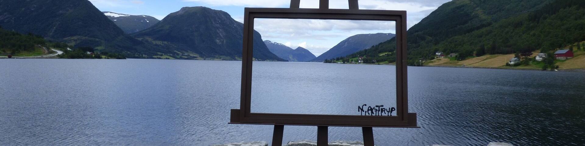 A lake with mountains in the background and a wooden dock.