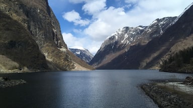A serene lake surrounded by rugged mountains with snow-capped peaks.