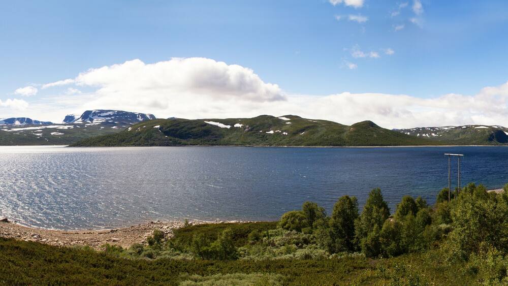 A lake surrounded by mountains and dense forest.