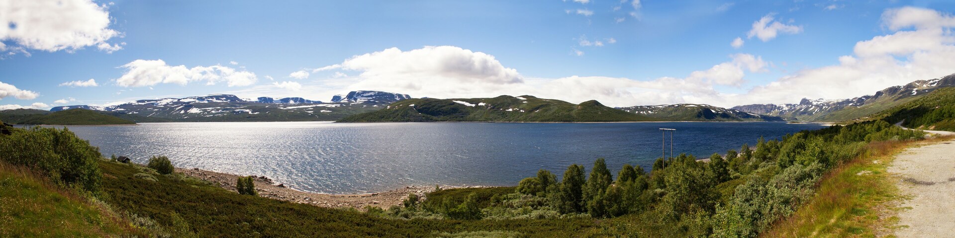Un lago rodeado de montañas y un bosque denso.