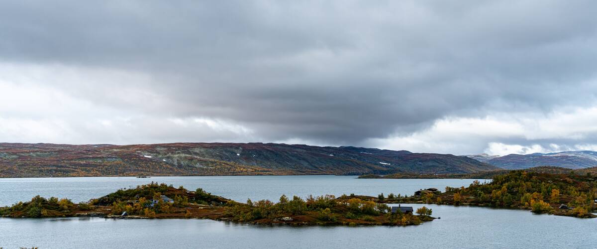 A lake surrounded by hills and autumn-colored trees.