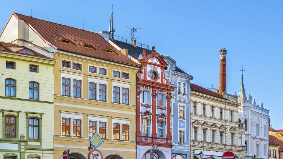 Colorful historic buildings with distinct architectural styles, including a clock tower and a church.