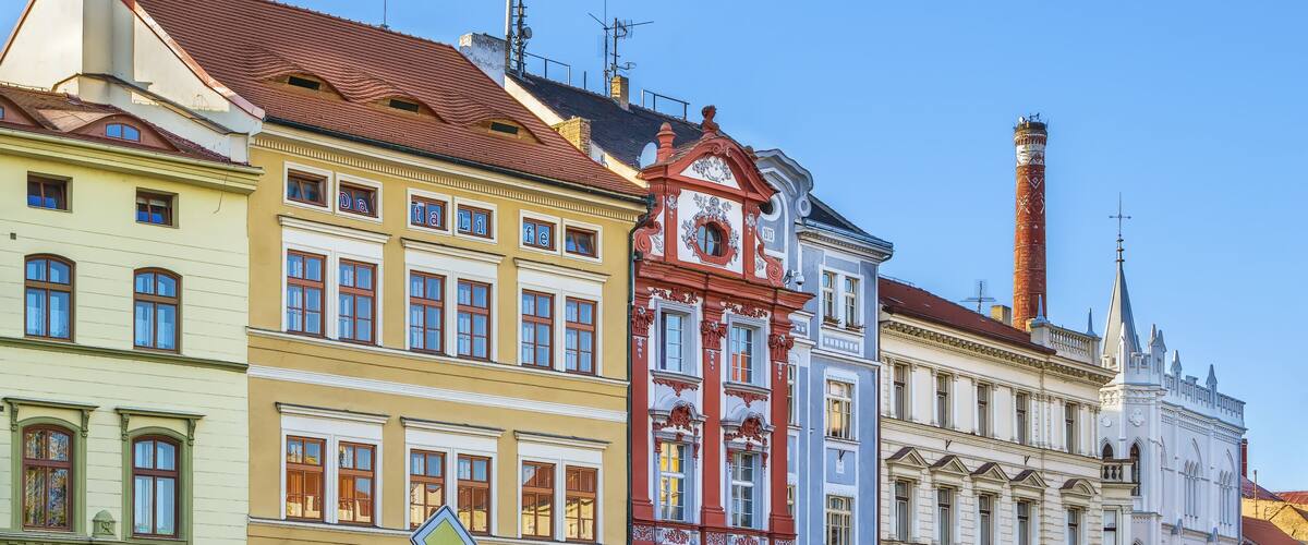 Colorful historic buildings with distinct architectural styles, including a clock tower and a church.