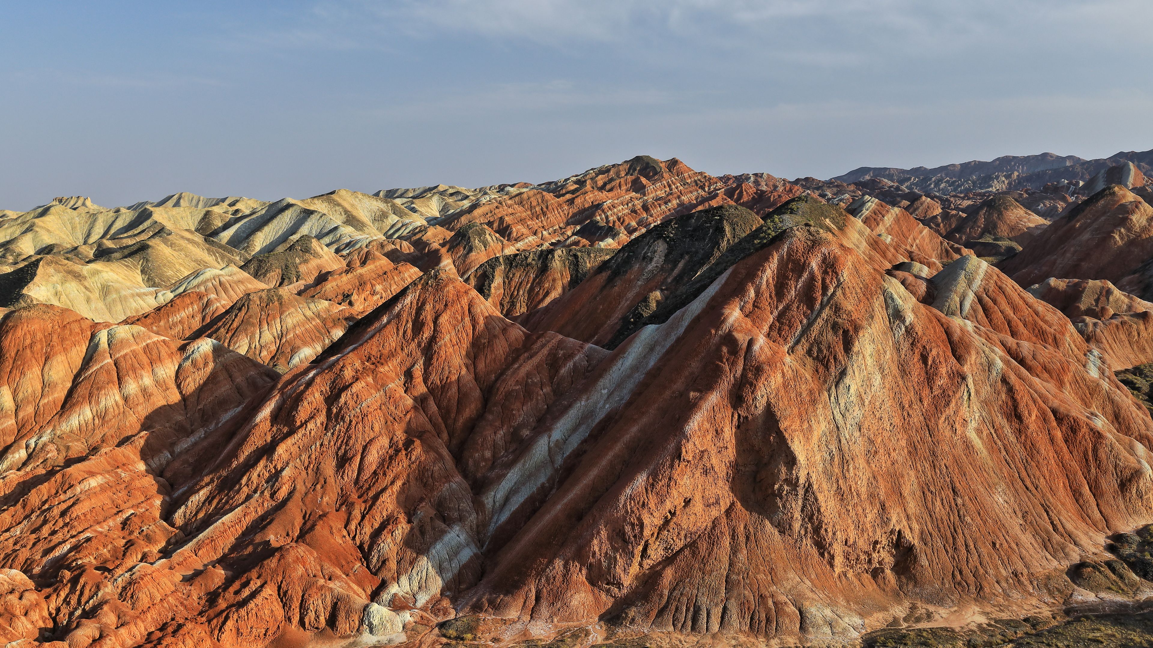 A rugged mountain range with distinct red and brown stratified rock formations.