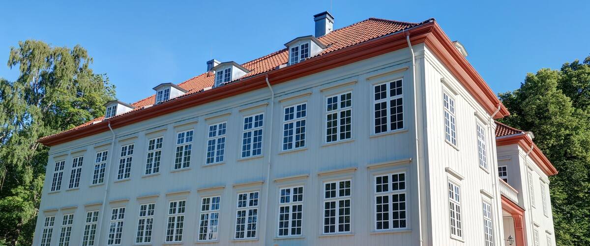 A large, white building with red trim and multiple windows.
