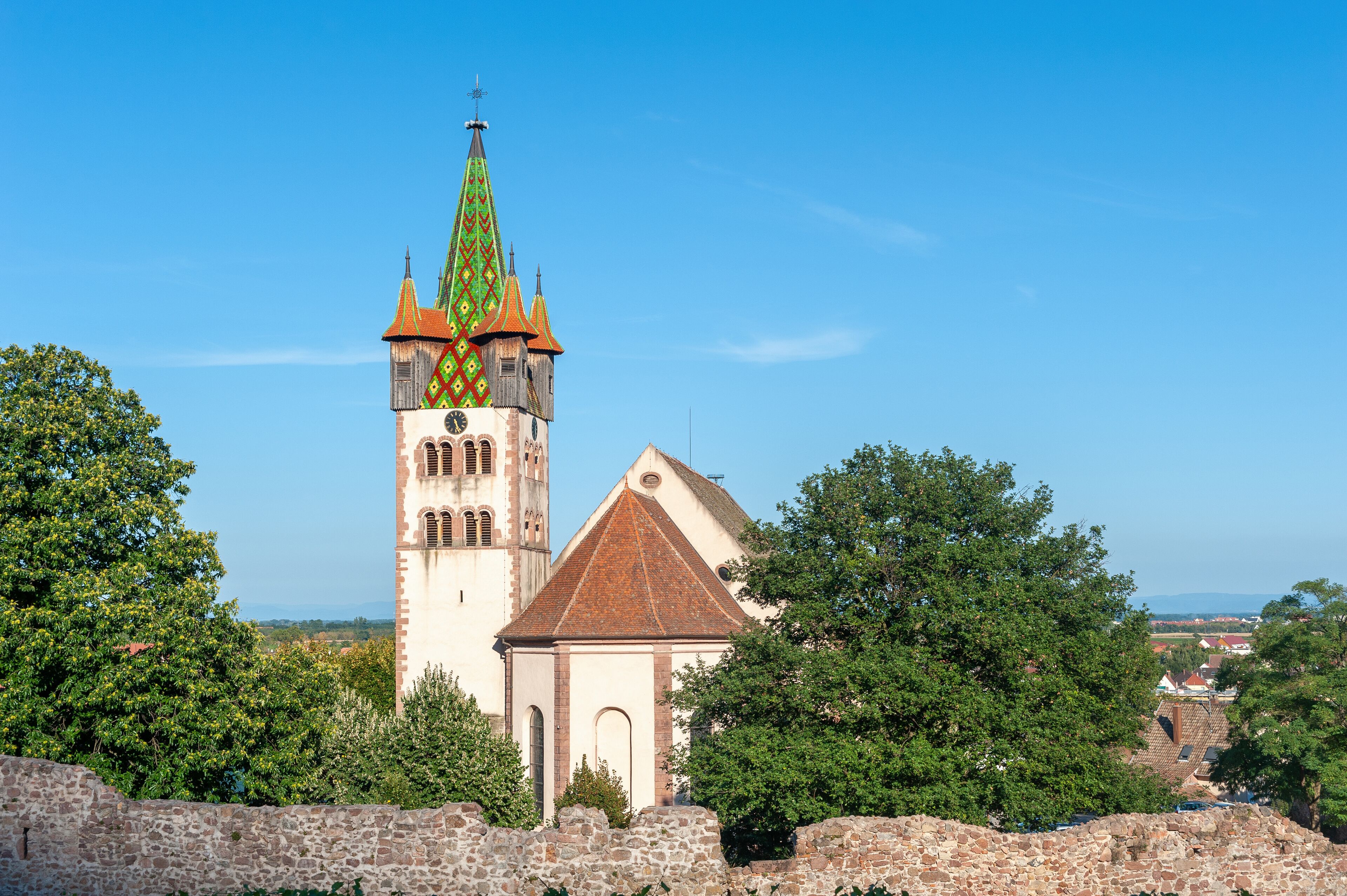 A church with a tall tower and a smaller building in a rural setting.