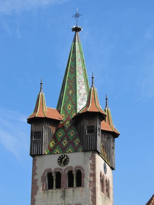 Una torre de iglesia con un reloj y una veleta.