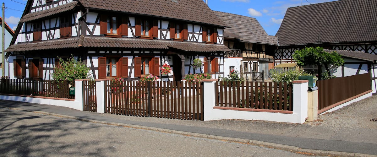 A traditional half-timbered house with a sloped roof and wooden shutters.