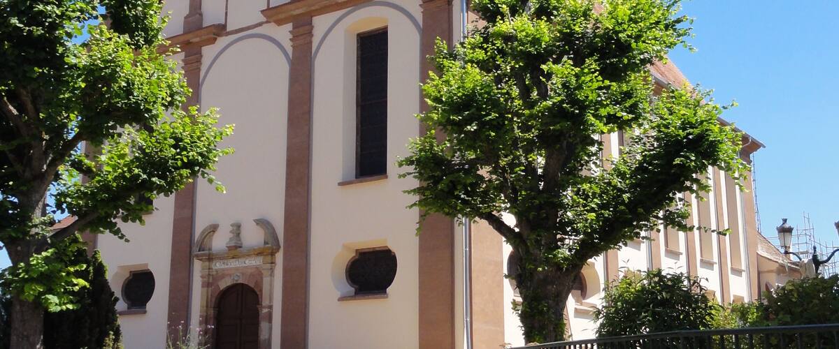 A church with a clock tower, a bell tower, and a large arched entrance.