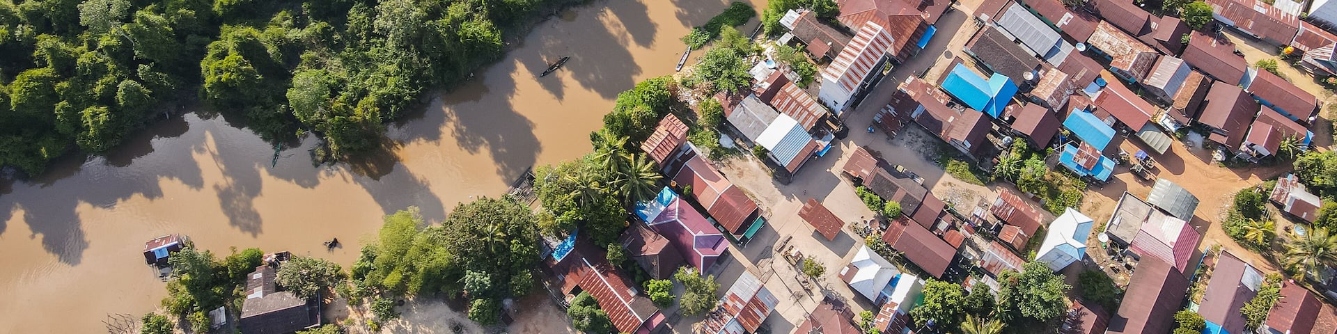 Residential center on the edge of a river and forest in a rural area, on the edge of a cross-regional road, in East Kotawaringin Regency, Central Kalimantan, Indonesia, seen from an aerial view.