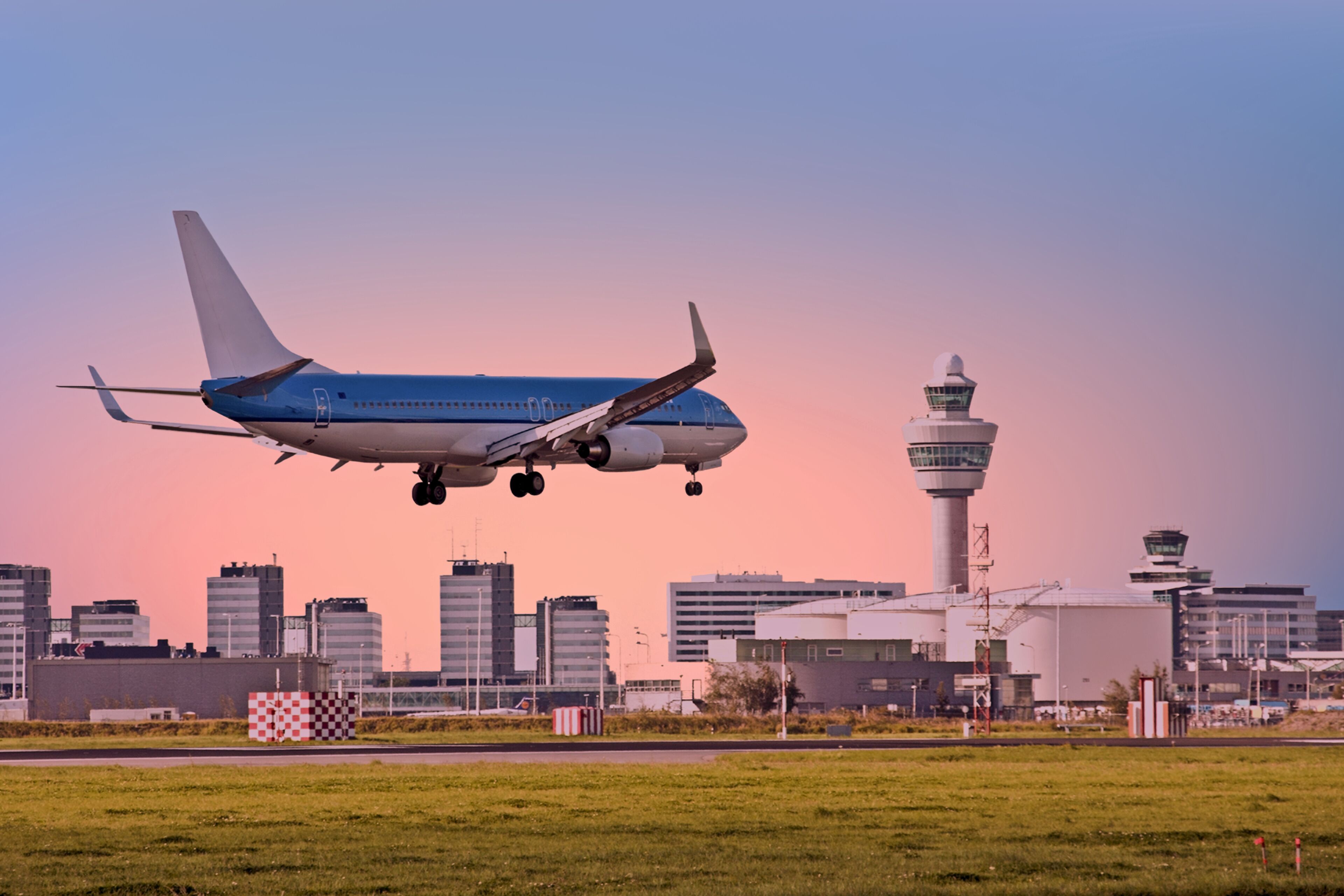 Ein Flugzeug startet mit einer Stadtlandschaft und einem Fluglotsenturm im Hintergrund.