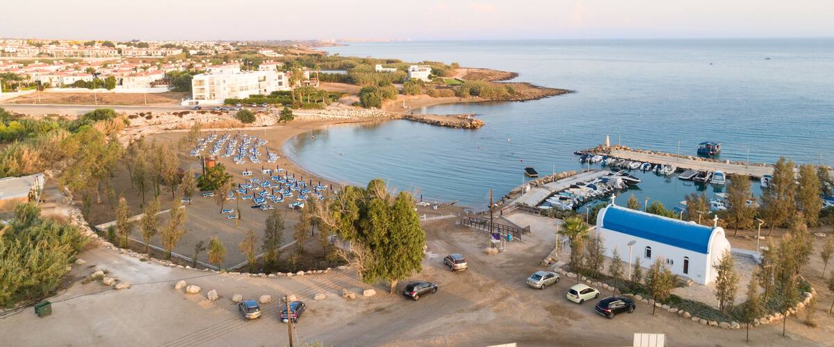 A coastal town with a marina, beach, and residential buildings.