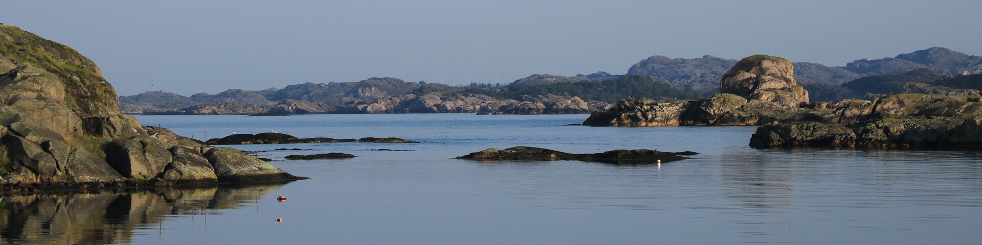 Un paisaje costero tranquilo con formaciones rocosas y agua en calma.