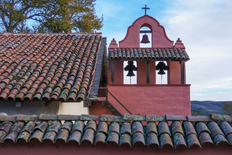 A church with a red bell tower and a tiled roof.
