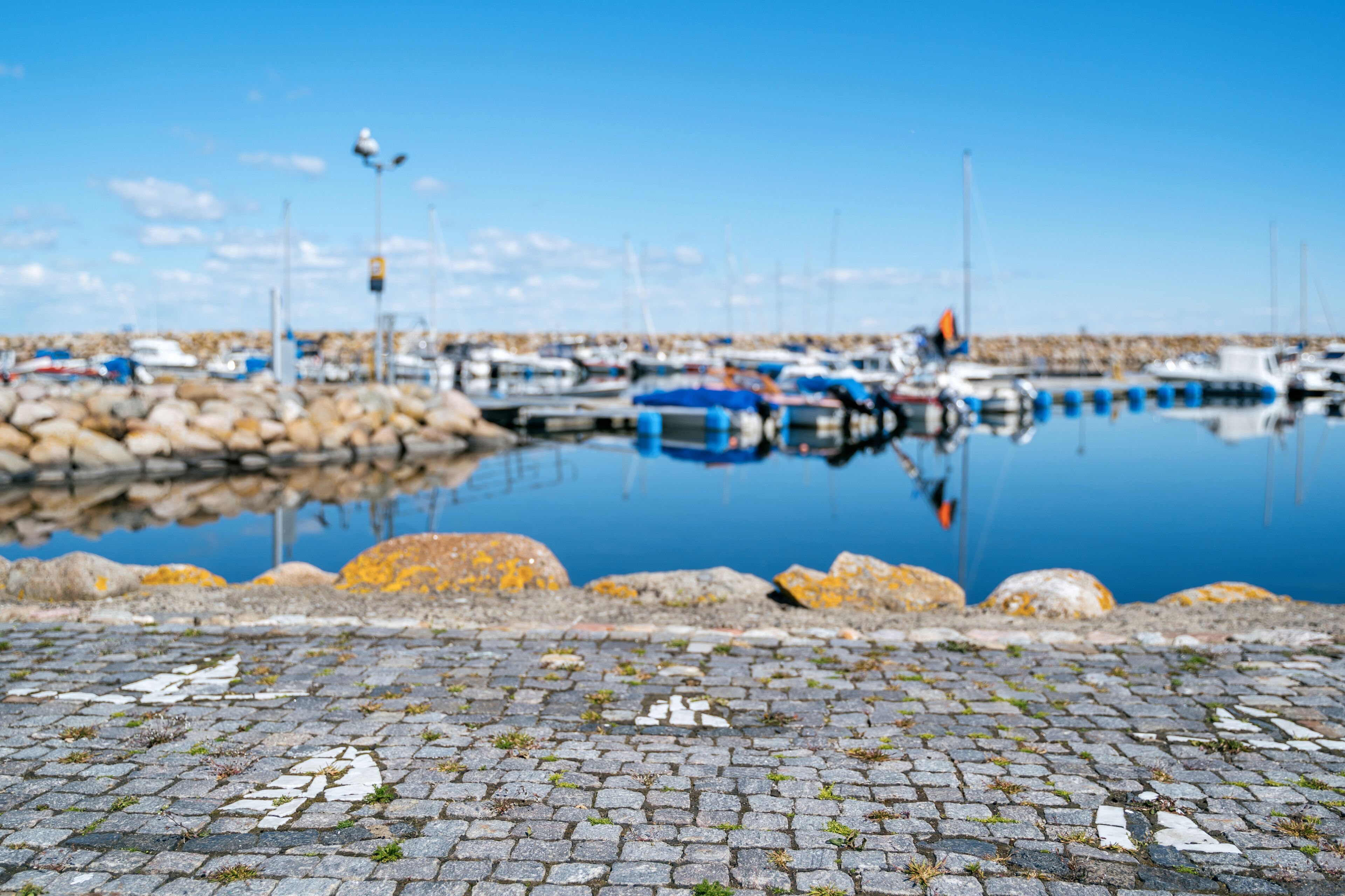 Simrishamn, Sweden - May 13, 2019: Boats at the marina on sunny day with reflectiom on water