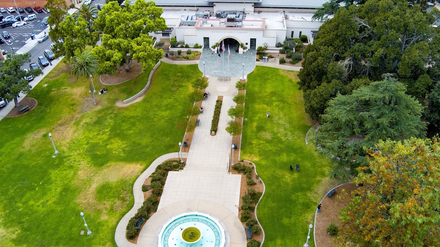 aerial shot of Library Park at the Monrovia Public Library with lush green trees and grass and cars on the street in Monrovia California USA