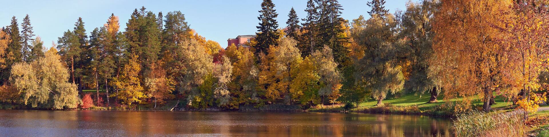 Northern European landscape in Finnish Kellokoski: golden autumn, rapids, Kerava river, sunny day, church near.