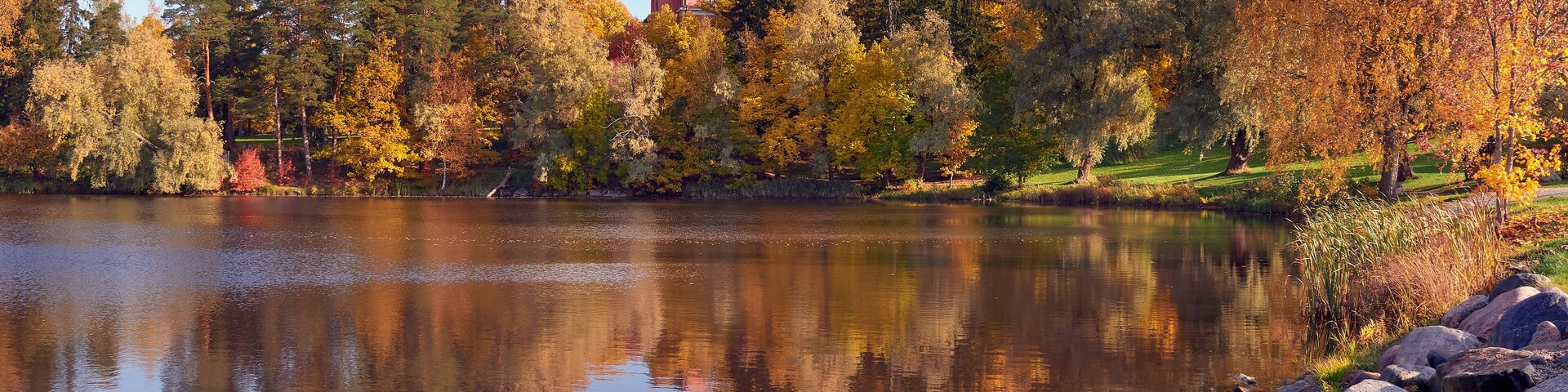 Northern European landscape in Finnish Kellokoski: golden autumn, rapids, Kerava river, sunny day, church near.