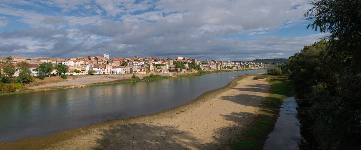 A river flowing through a town with buildings along the riverbank.
