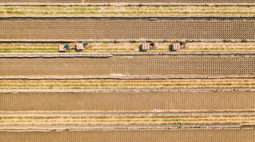 Aerial view of a brick factory from above, people working arranging the bricks near Keraniganj township, Dhaka province, Bangladesh.