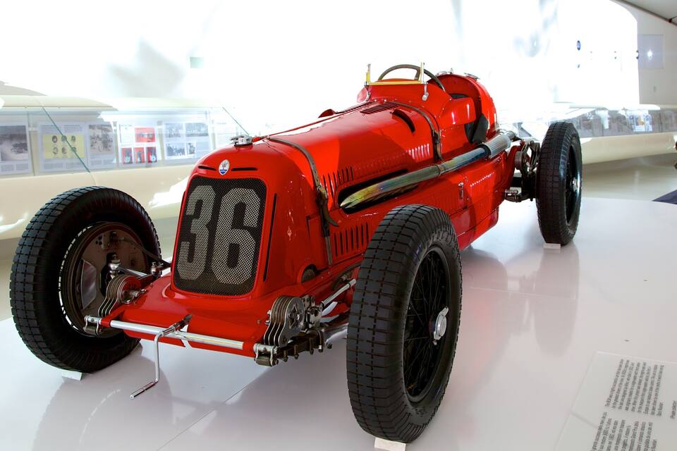 Un automóvil clásico rojo, con neumáticos grandes y un diseño atemporal.