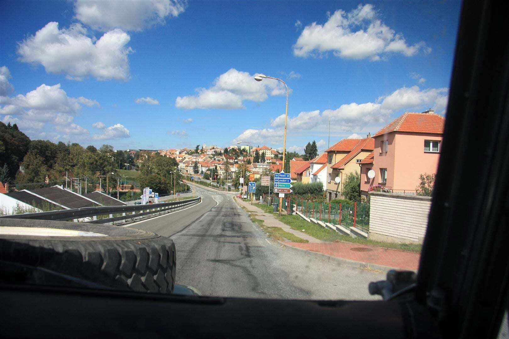 A road with a blue sign indicating directions to 'Prague' and 'Bratislava'.