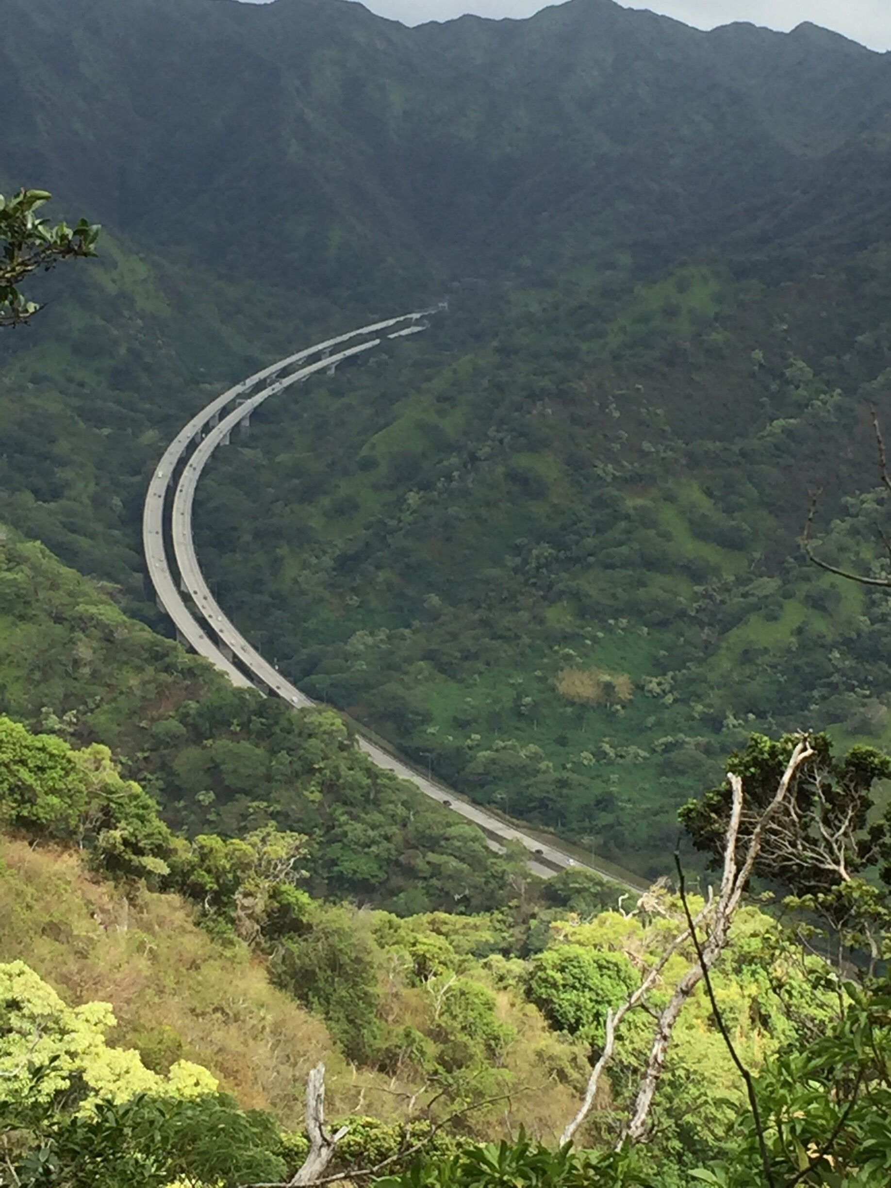 A winding highway through a lush, green mountainous landscape.